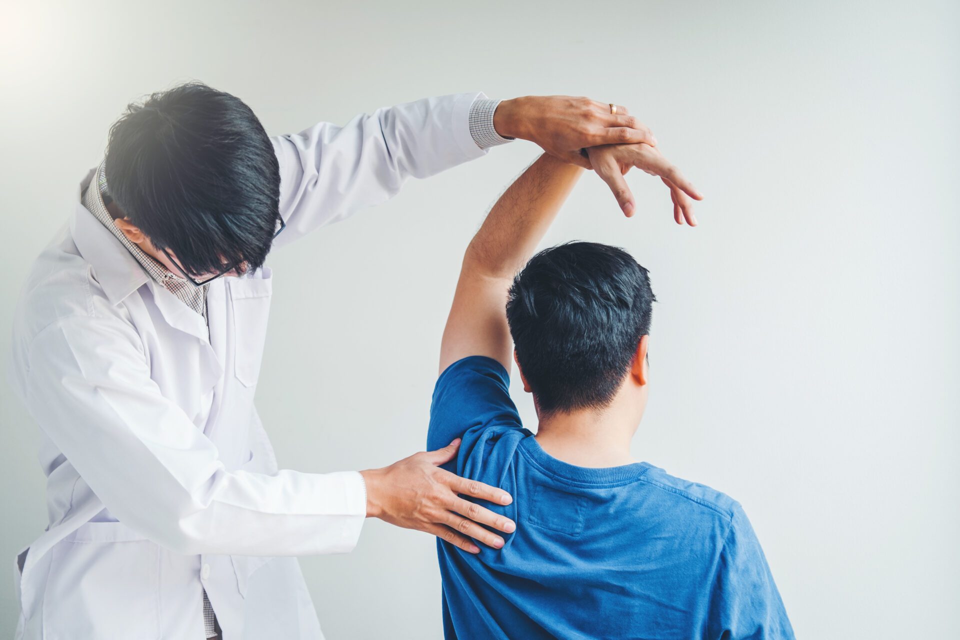 Physical Doctor consulting with patient About Shoulder muscule p A person holed a equipment for scanning body